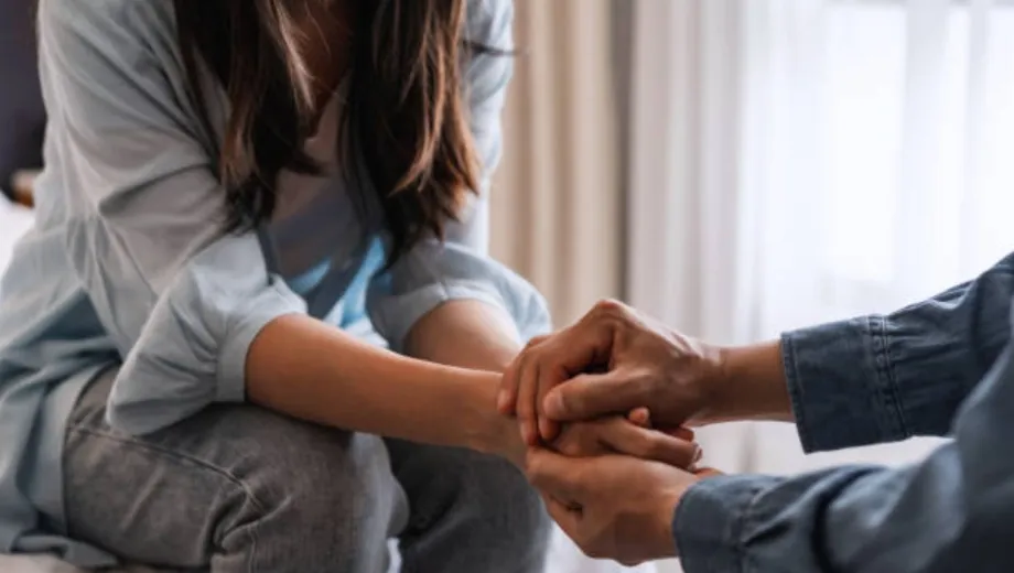 Manos entrelazadas en un gesto de apoyo y esperanza en medio de la adicción, recordando que la recuperación no es rendirse, sino elegir lo vital para sanar en familia.